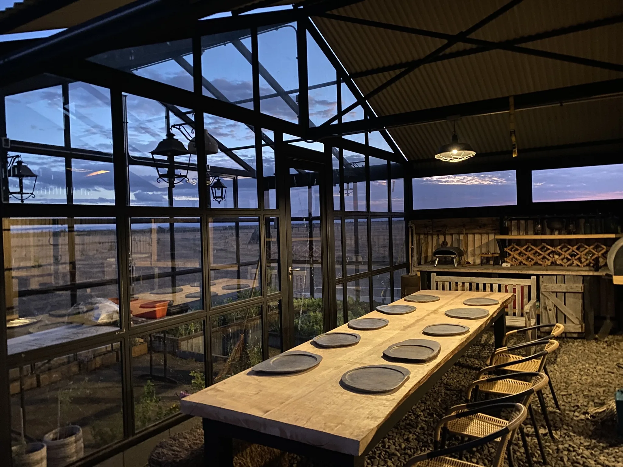 Long dining table inside the greenhouse quincho at Patagonia Edén